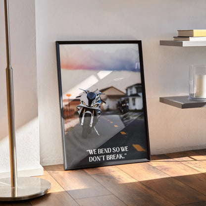 Motivational poster featuring BMW S1000RR motorcycle with inspiring text, framed wall art on wooden floor.