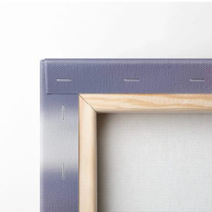 Close-up of stretched canvas wall art with wooden frame and gradient blue-gray edges.