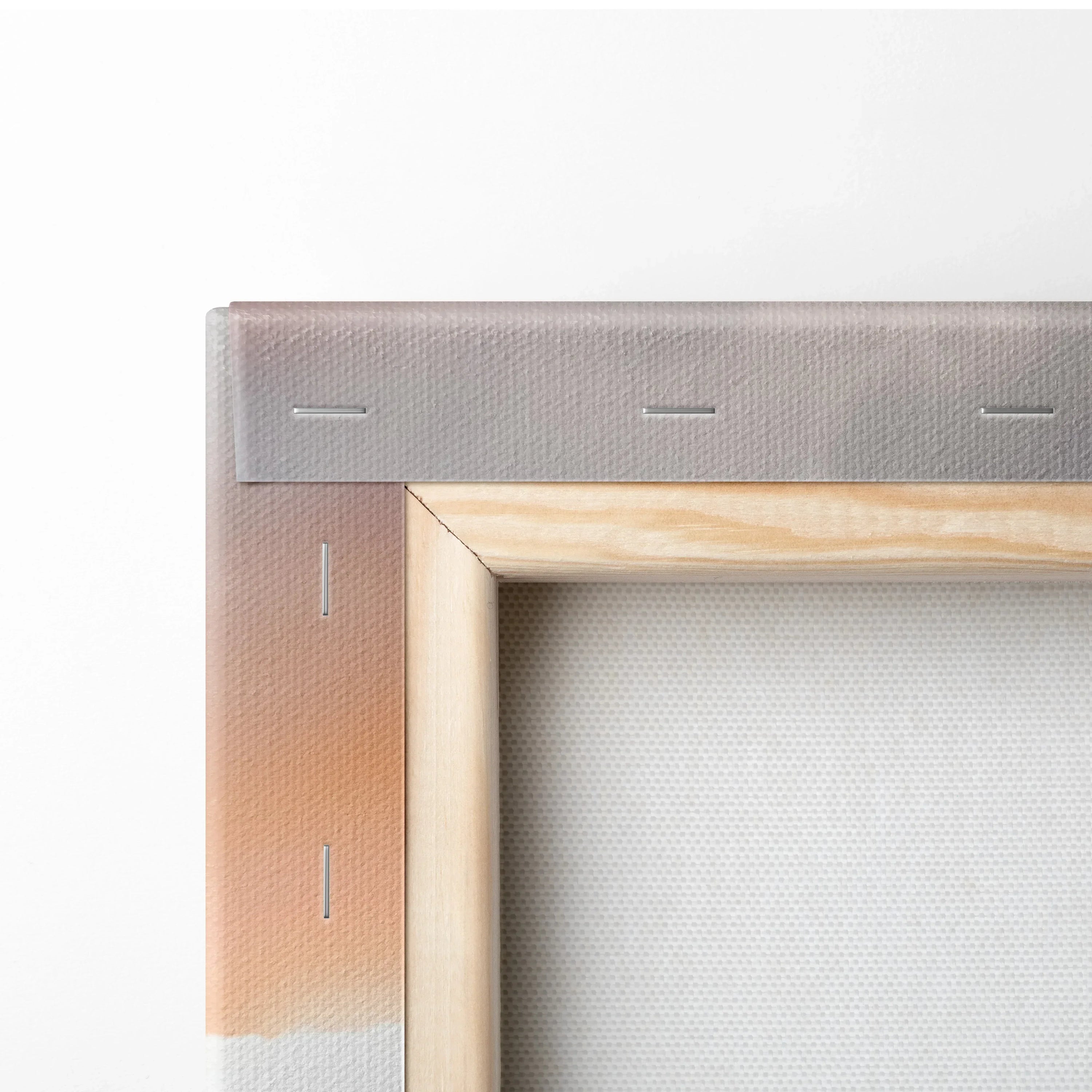 Close-up of wooden framed canvas wall art showing textured fabric and secure metal staples on corner.