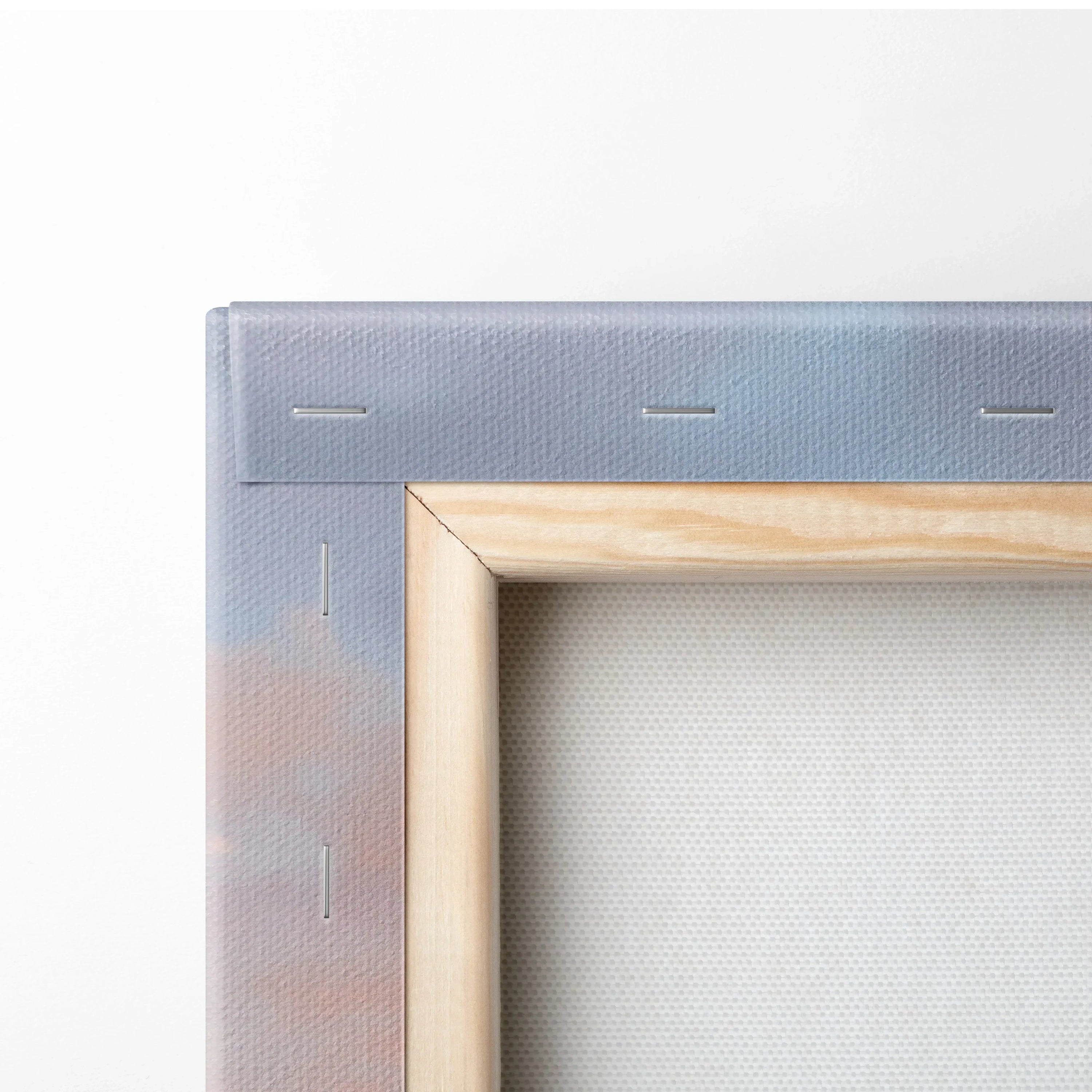 Close-up of wooden canvas frame with fabric stretched and stapled for wall art print.