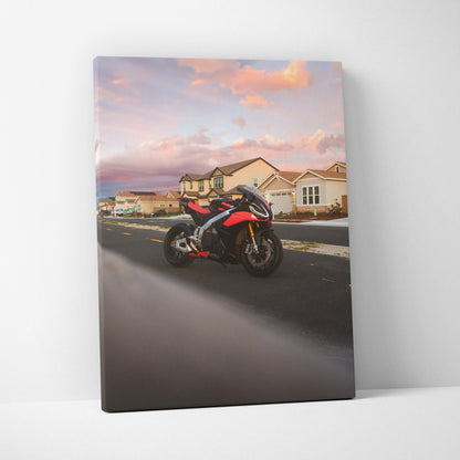 Vertical canvas wall art featuring a red and black Aprilia RSV4 motorcycle on a suburban street at sunset.