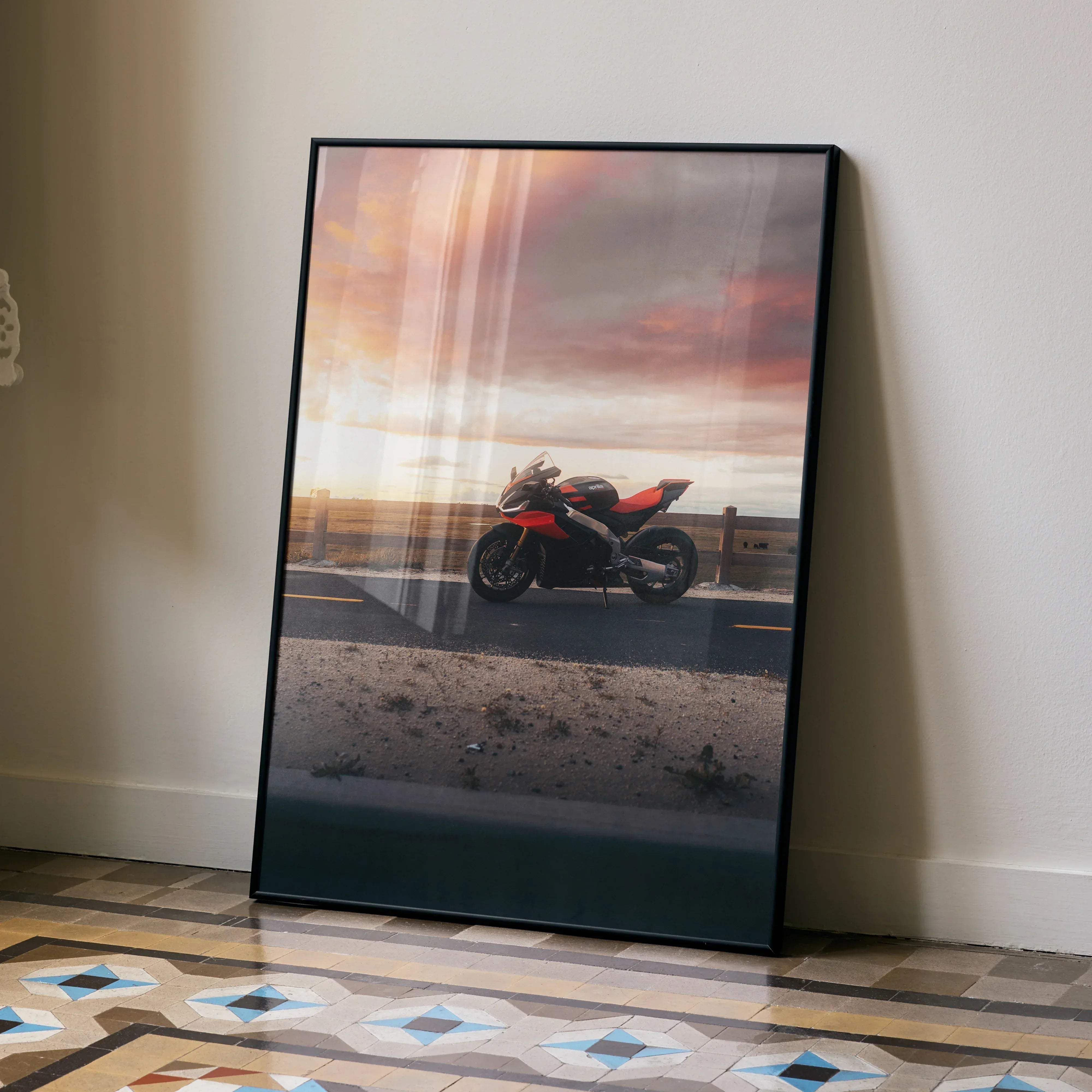 Black-framed Aprilia RSV4 1100 Factory motorcycle art print featuring a red and black sport bike at sunset