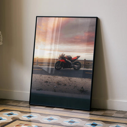 Aprilia RSV4 motorcycle sunset poster wall art in black frame leaning on beige wall.