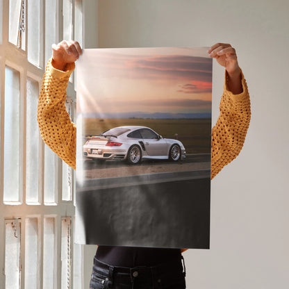 Porsche 911 Turbo on road at sunset poster wall art with soft pink and orange sky.