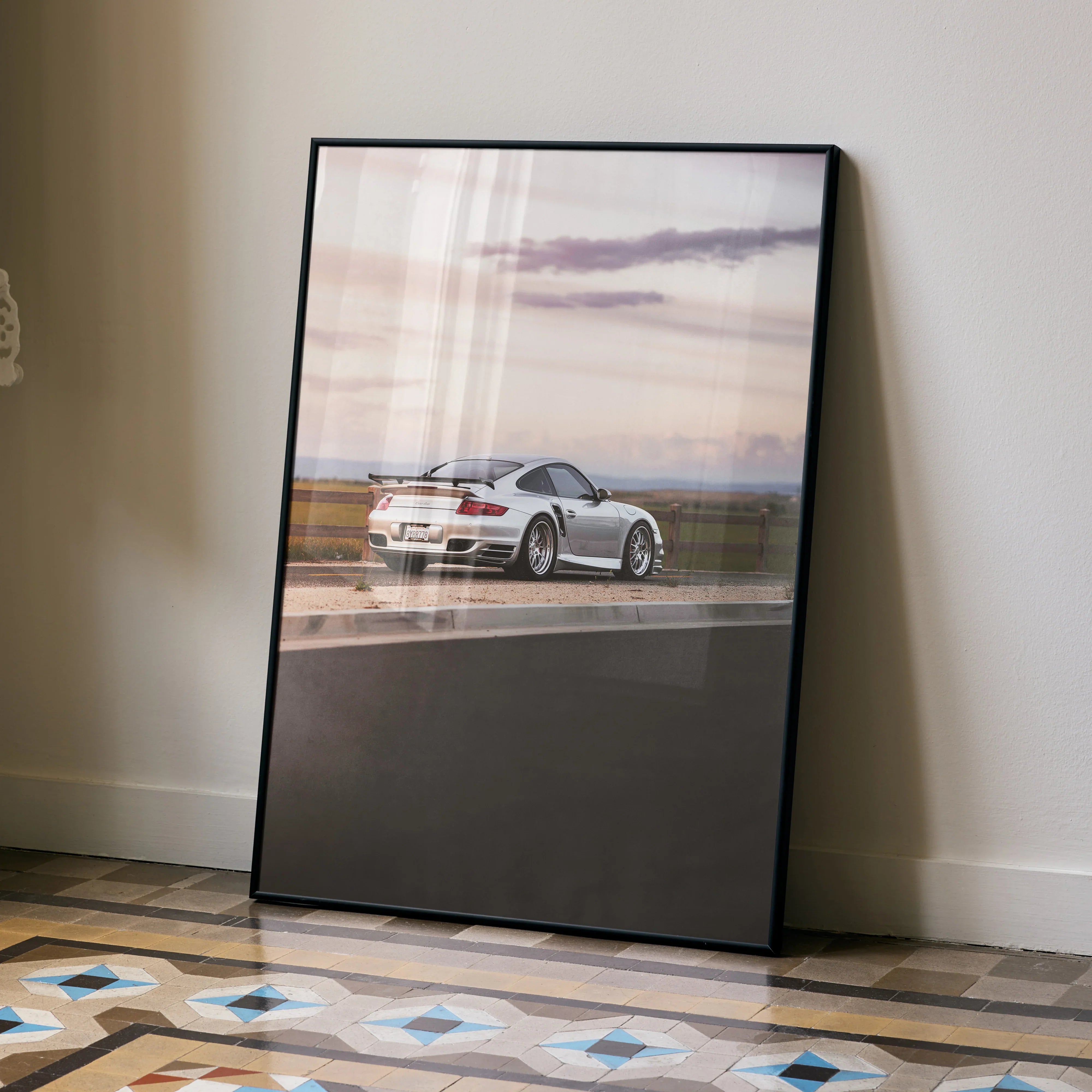 Porsche 911 Turbo poster leaning on wall with scenic sunset background luxury wall art.