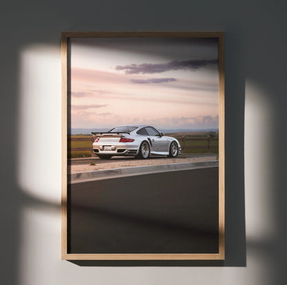 Porsche 911 Turbo poster showing white sports car on racetrack at sunset, luxury wall art.