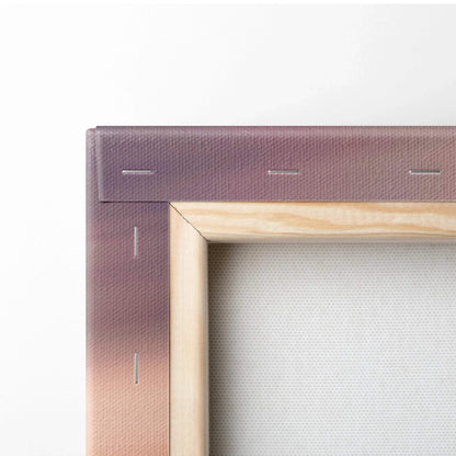 Close-up of stretched canvas with wooden frame and sunset gradient wall art background.