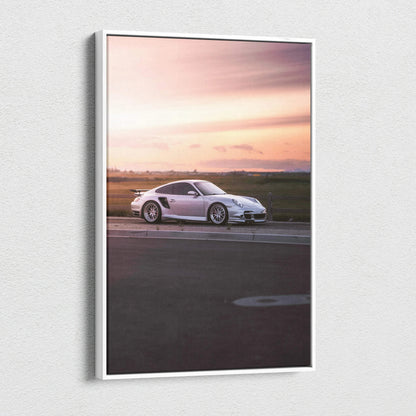 Vertical canvas wall art featuring a white Porsche 911 Turbo against a soft sunset sky.