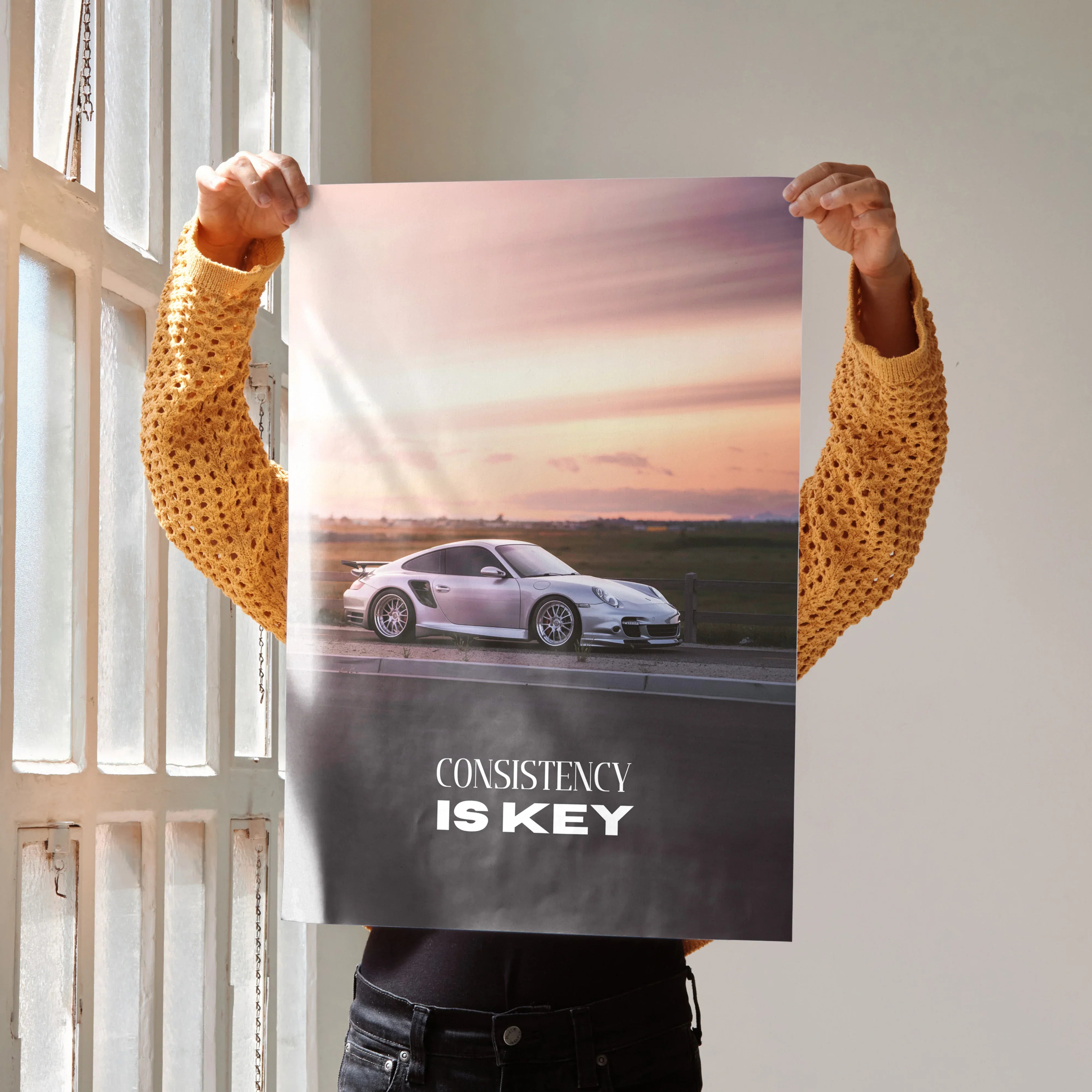 Motivational poster wall art featuring white Porsche 911 Turbo on sunset road with "Consistency Is Key" text.
