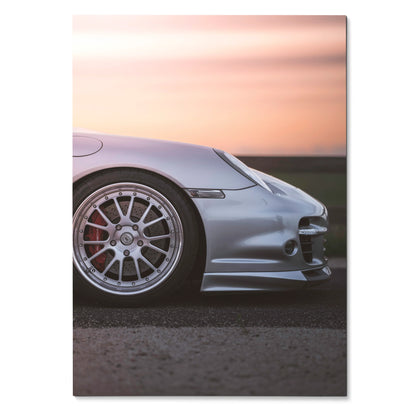 Porsche 911 Turbo poster featuring silver car front wheel and sleek front bumper against sunset wall art.