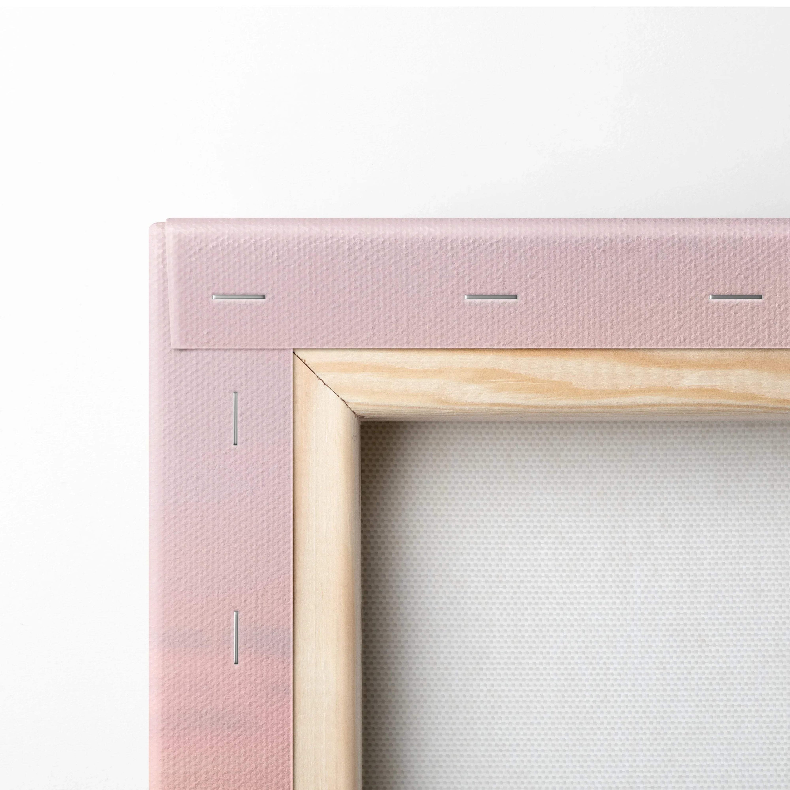 Close-up of stretched canvas art with wooden frame and stapled pink fabric backing for wall art display.