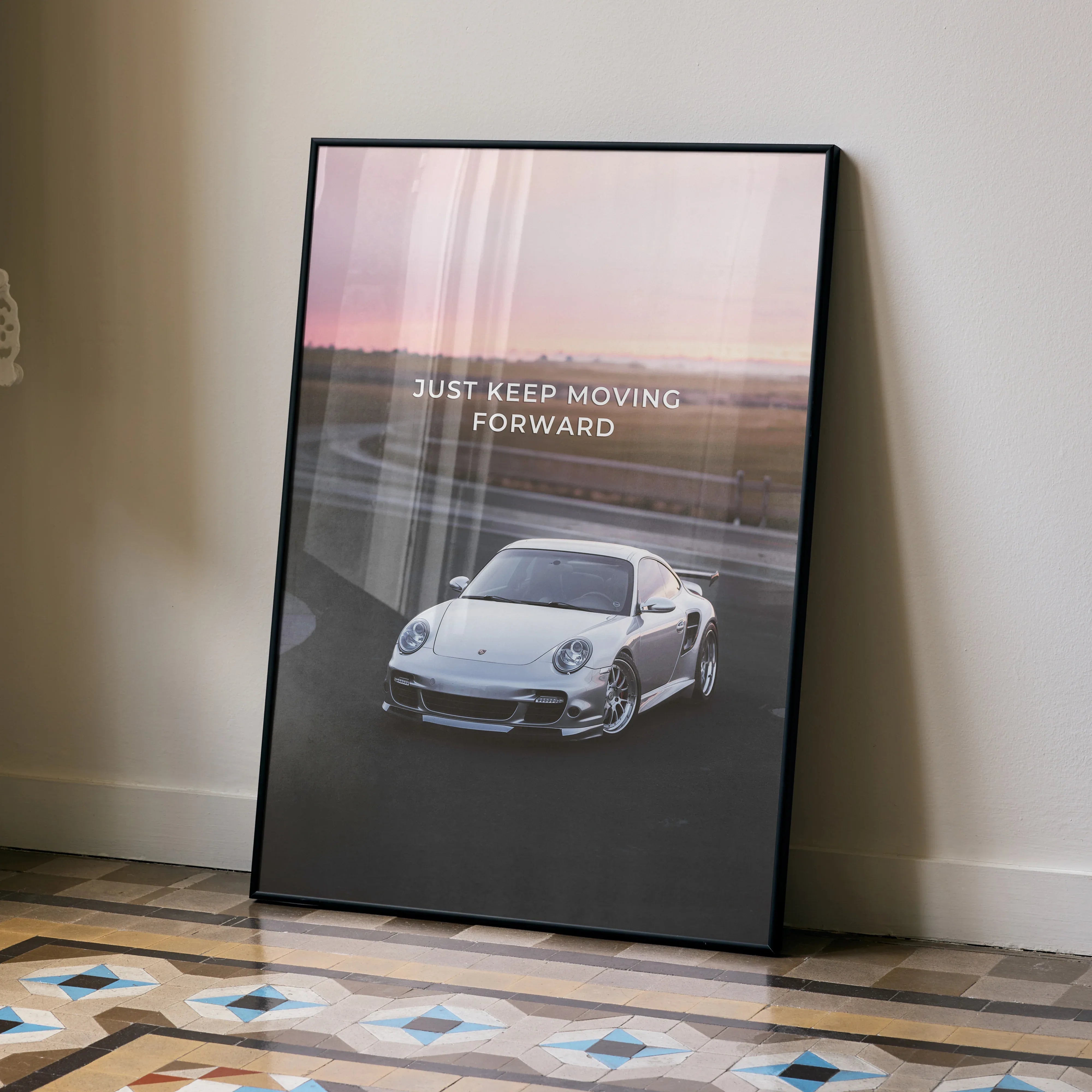 Motivational poster featuring a white Porsche 911 Turbo with "Just Keep Moving Forward" text, wall art with a sunset.