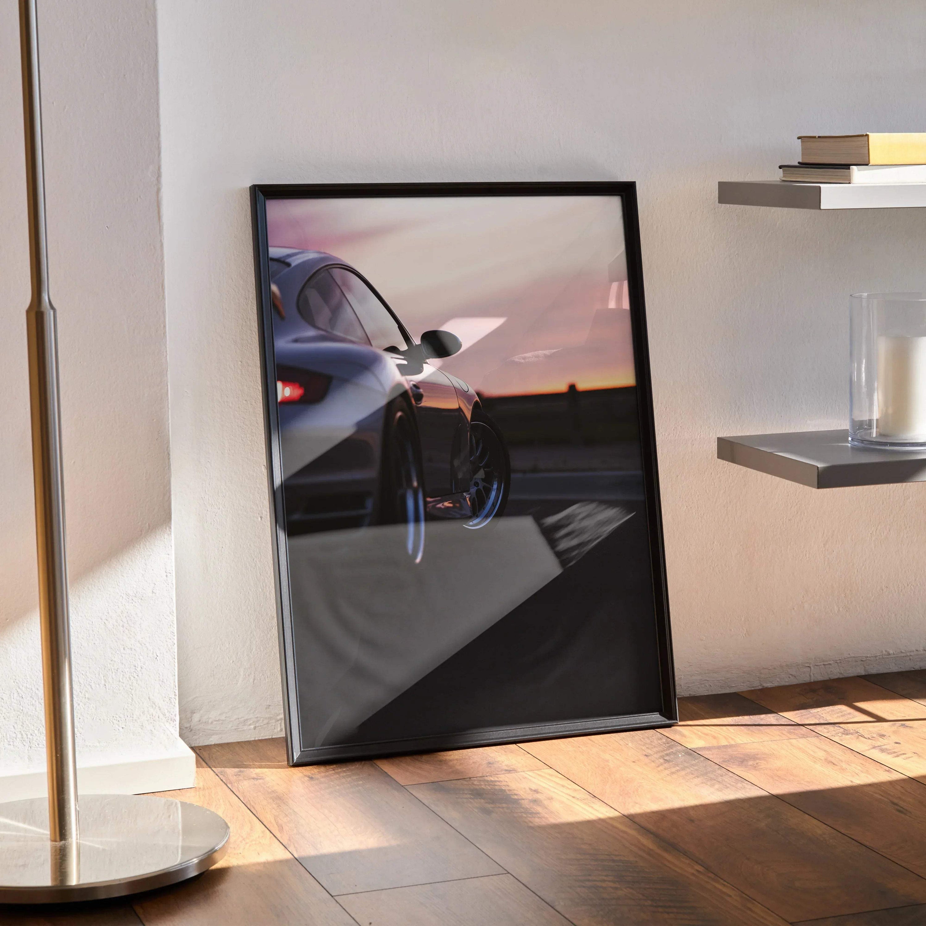 Porsche 911 Turbo reflected on glossy black wall art poster in sleek black frame leaning on floor.