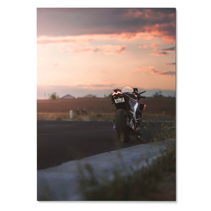 Aprilia RSV4 1100 Factory motorcycle at sunset poster wall art with blurred foreground and dramatic sky.