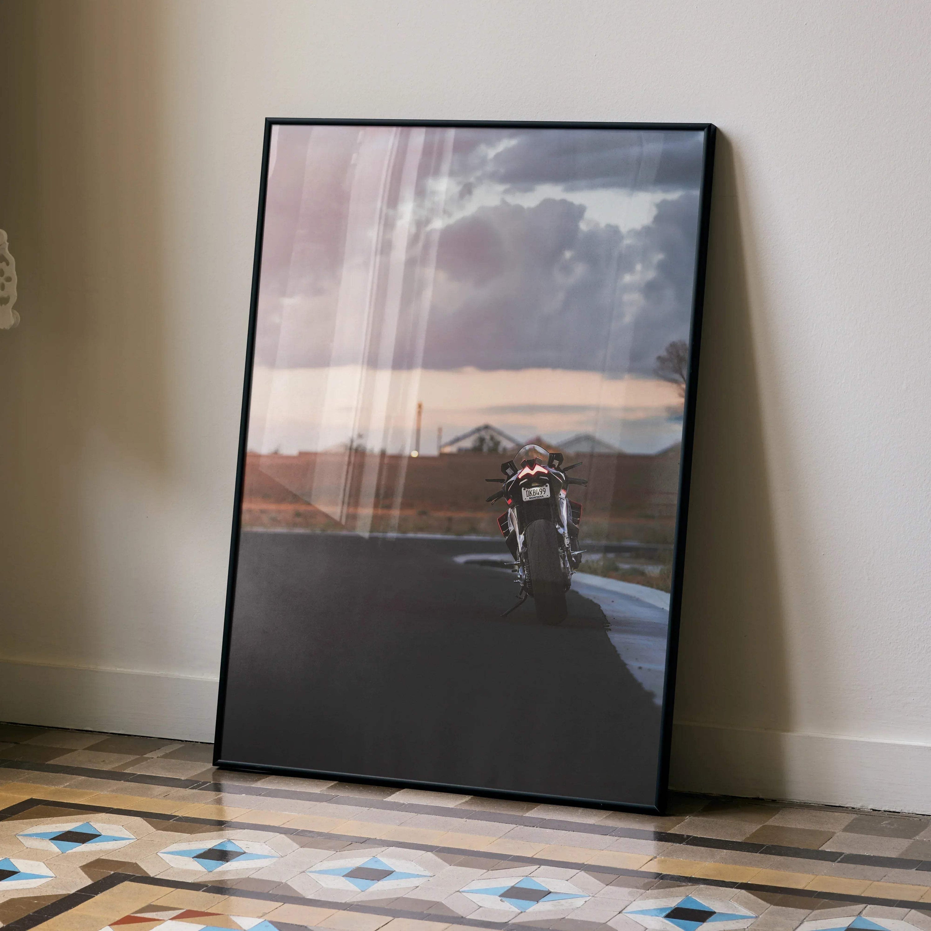 Aprilia RSV4 1100 Factory motorcycle riding at sunset poster wall art with moody sky background.