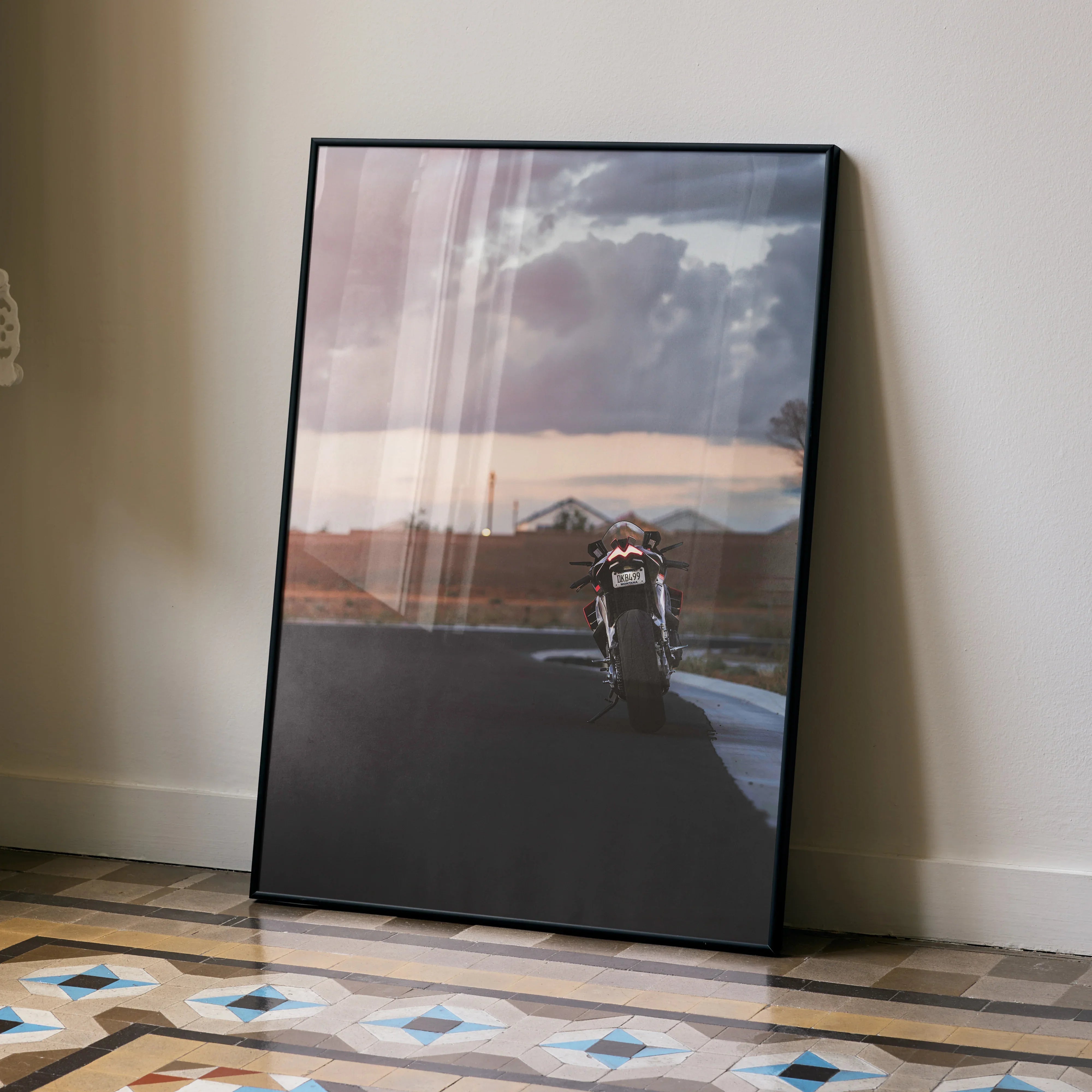 Aprilia RSV4 1100 Factory motorcycle riding at sunset poster wall art with moody sky background.