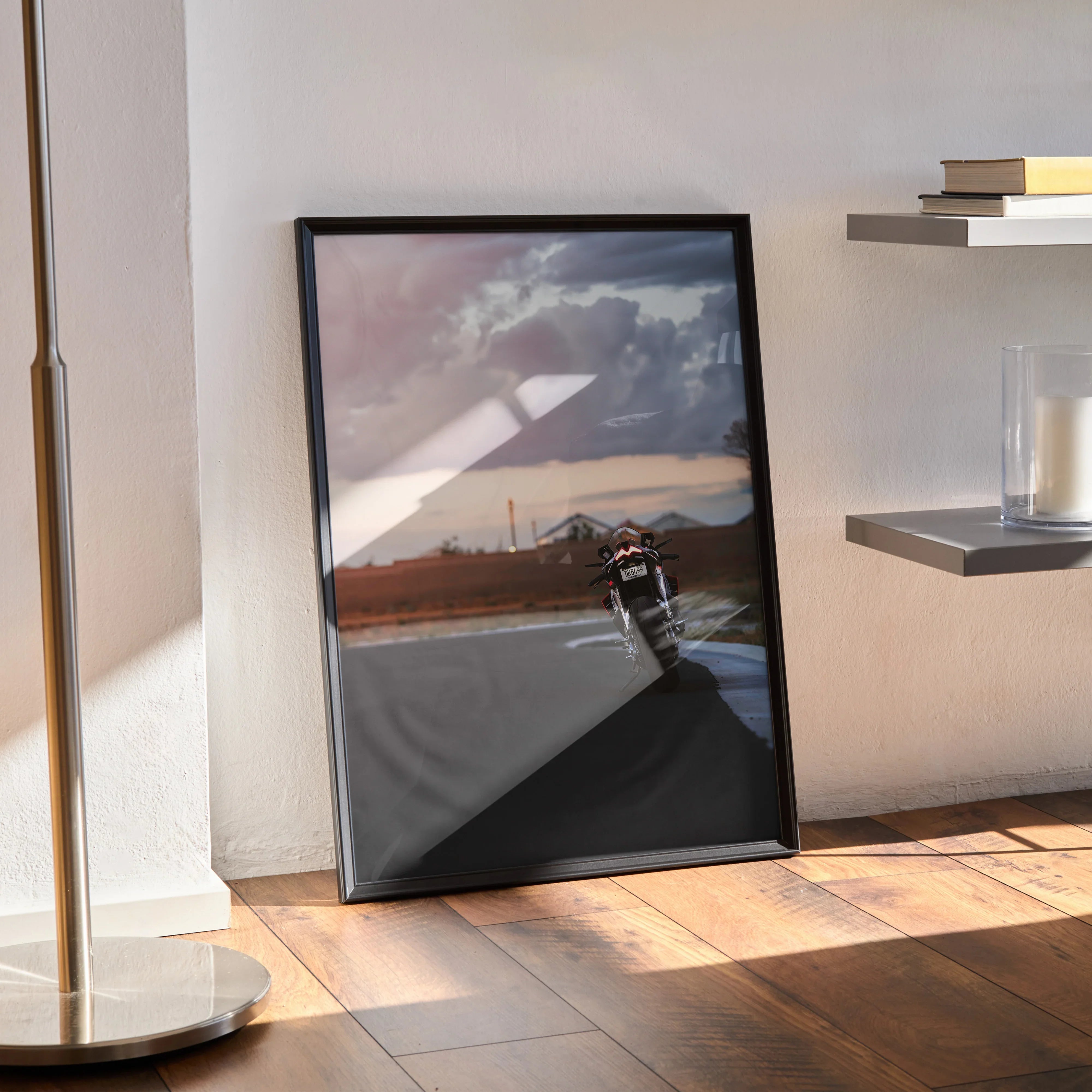 Aprilia RSV4 1100 Factory motorcycle poster with sunset background framed wall art leaning on floor.