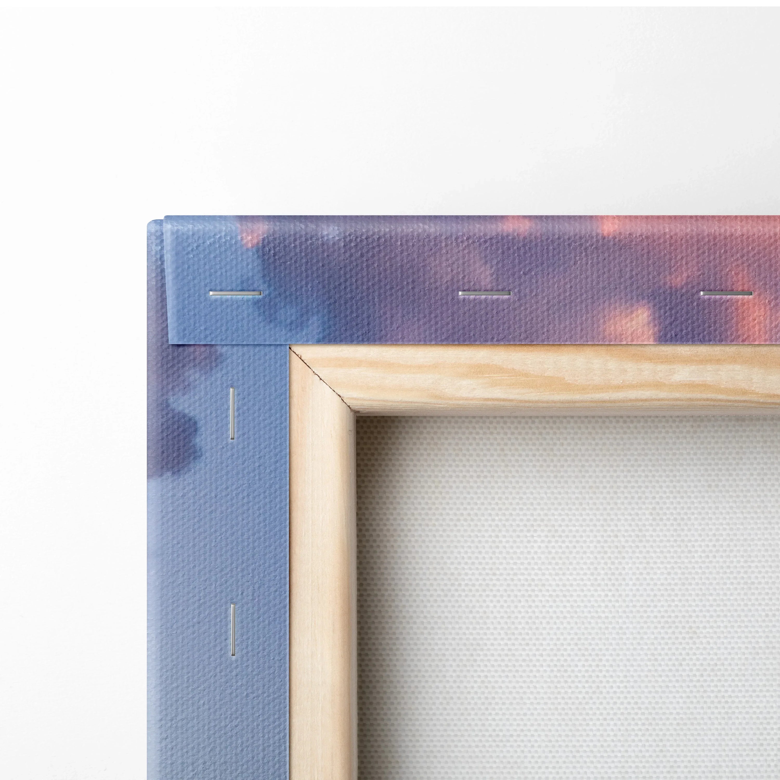 Close-up of wooden frame and canvas fabric with blue and purple sunset tones, wall art detail.