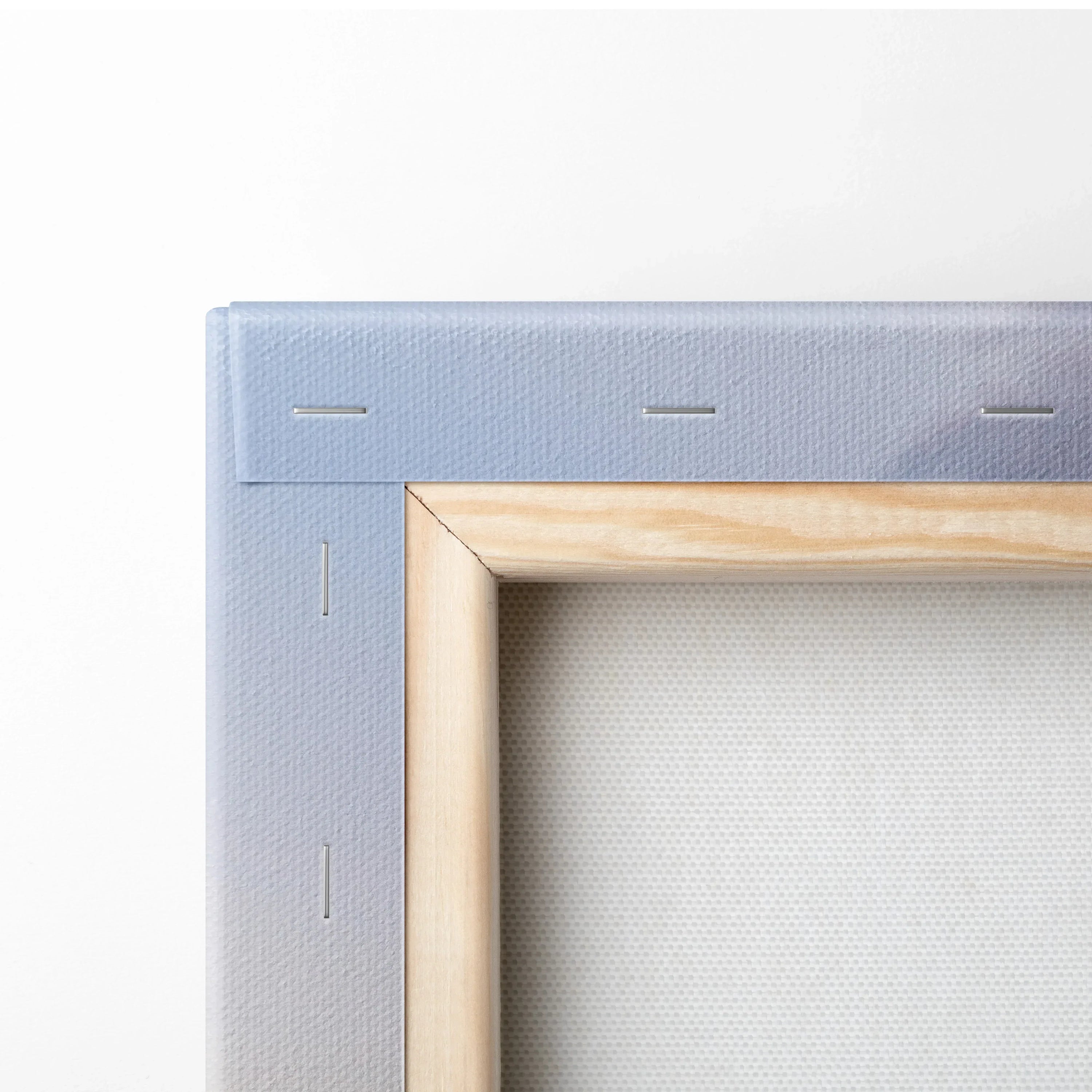 Close-up of wooden frame and canvas back with staples for vertical wall art print.