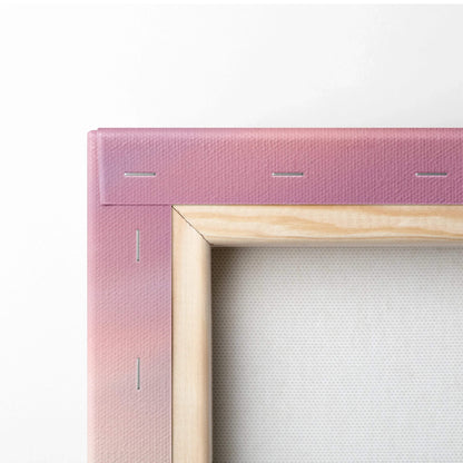 Close-up of wooden frame and pink canvas corner with visible staples for wall art mounting.