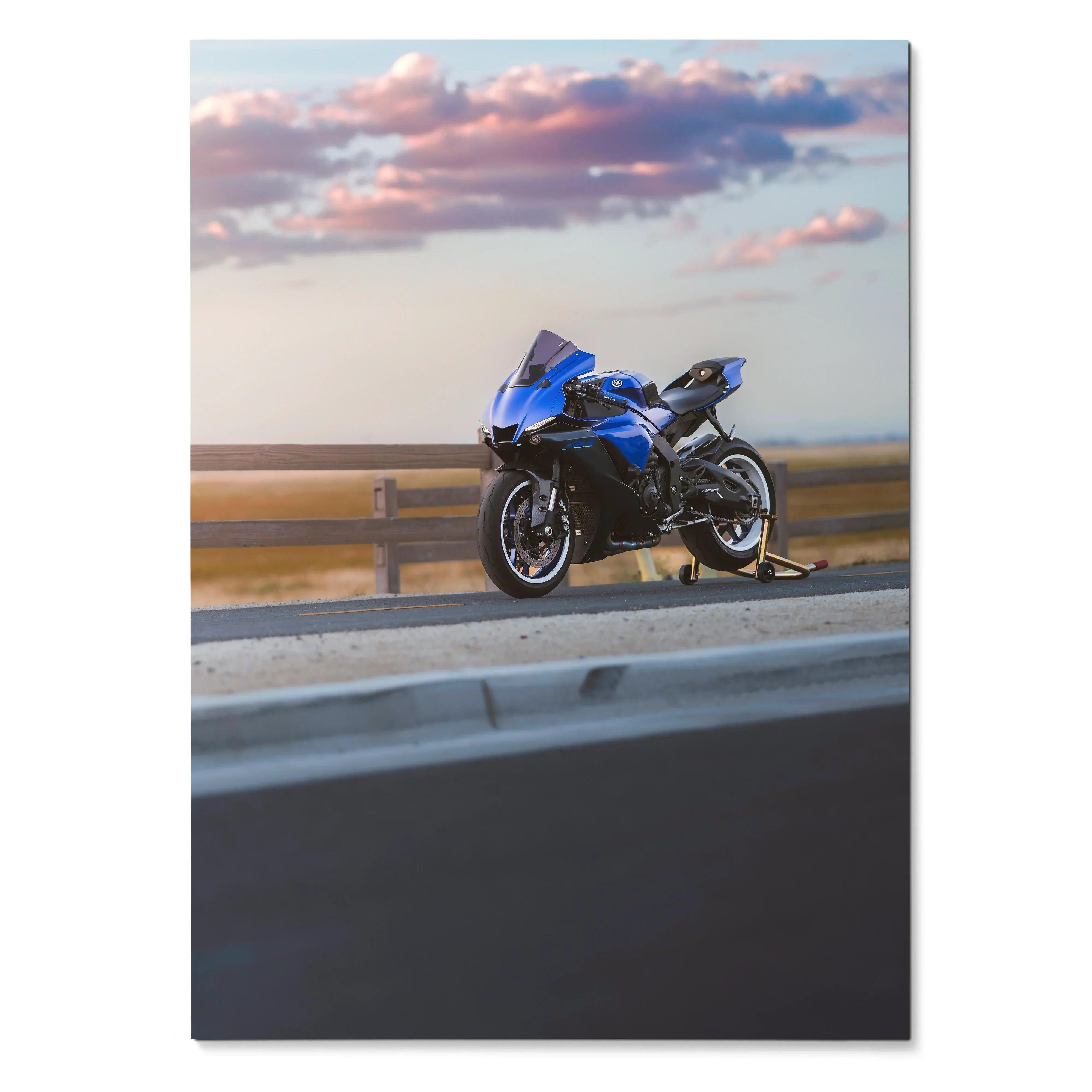Blue Yamaha YZF-R1 motorcycle against sunset sky on asphalt road poster wall art.