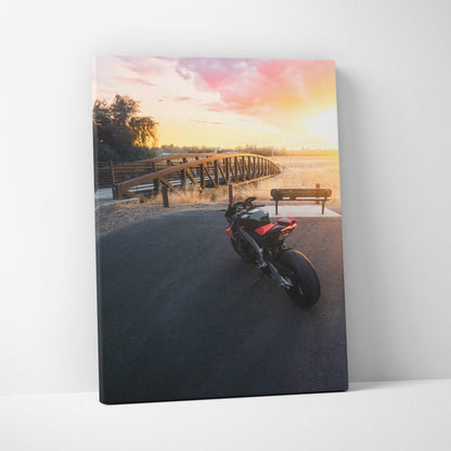 Aprilia RSV4 1100 Factory motorcycle at sunset on canvas wall art with vibrant sky and bridge background.