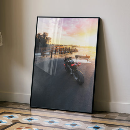 Aprilia RSV4 motorcycle parked near pier at sunset Poster wall art in black frame.