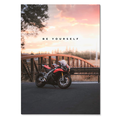 Motivational poster wall art featuring Aprilia RSV4 1100 Factory motorcycle with sunset background and "Be Yourself" text.