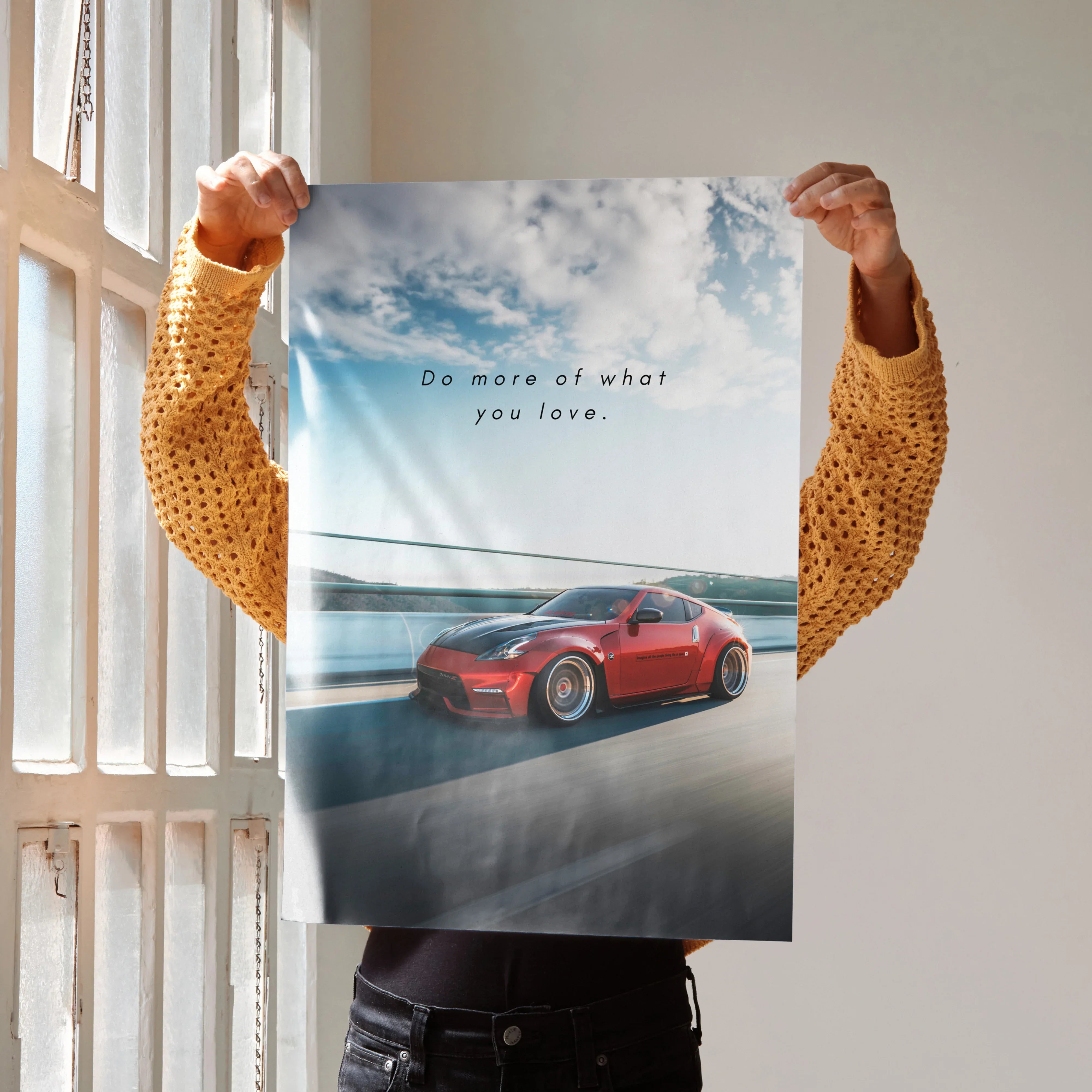 Motivational poster wall art featuring a red Nissan 370z driving on a road with sky background and inspiring text.