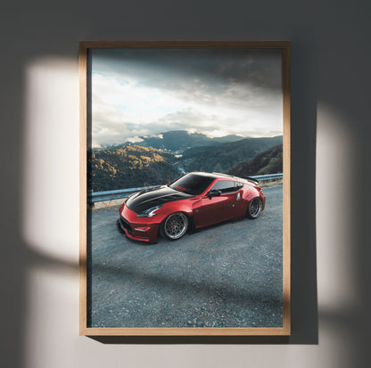 Red Nissan 370Z sports car wall art poster with mountain landscape background in a wooden frame.