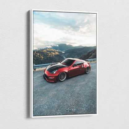 Red Nissan 370z sports car on mountain road canvas wall art with clear sky background.