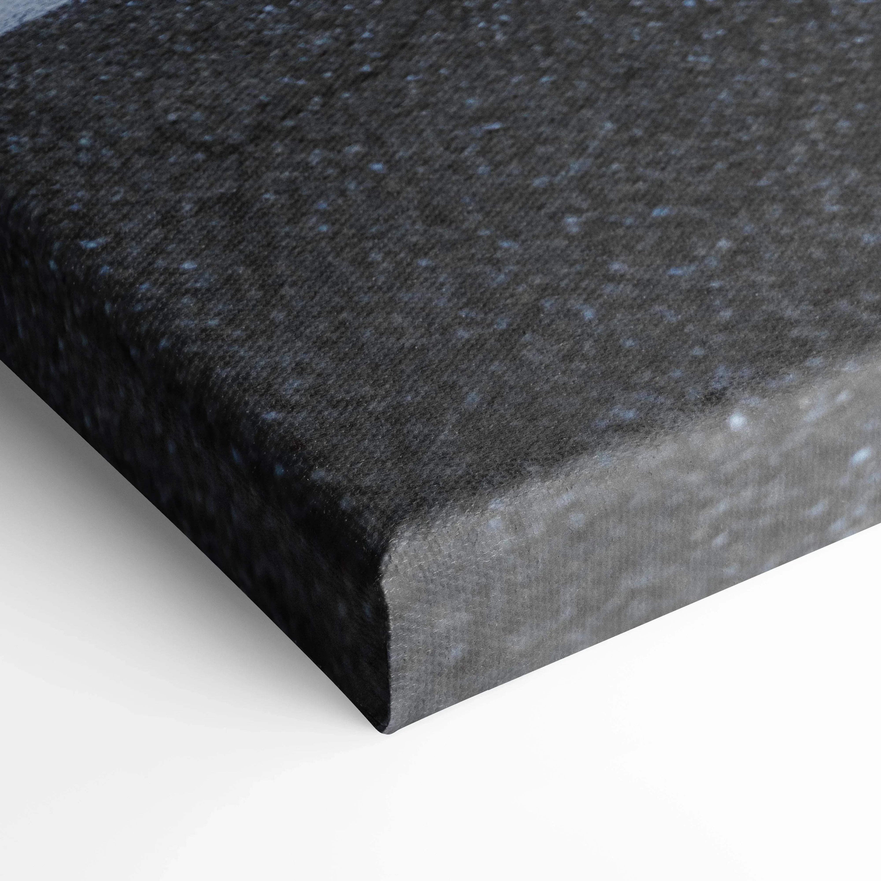 Black textured canvas art stretched over wooden frame corner, vertical wall art detail.