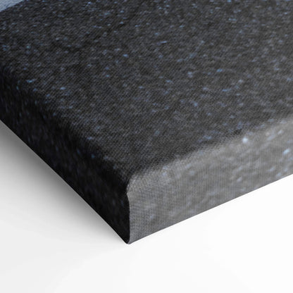 Black textured canvas art stretched over wooden frame corner, vertical wall art detail.