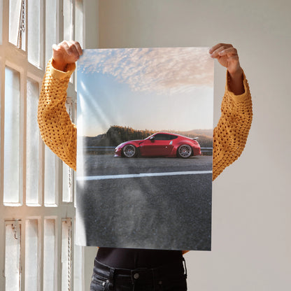 Red Nissan 370Z on road with blue sky, high resolution poster wall art for car enthusiasts.