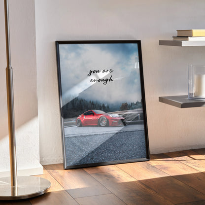 Framed motivational poster wall art featuring a red Nissan 370z with "You are enough" text against a misty mountain.