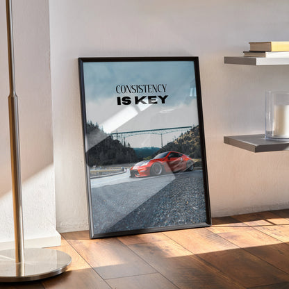 Motivational poster featuring red Nissan 370z on racetrack with "Consistency is Key" text wall art.