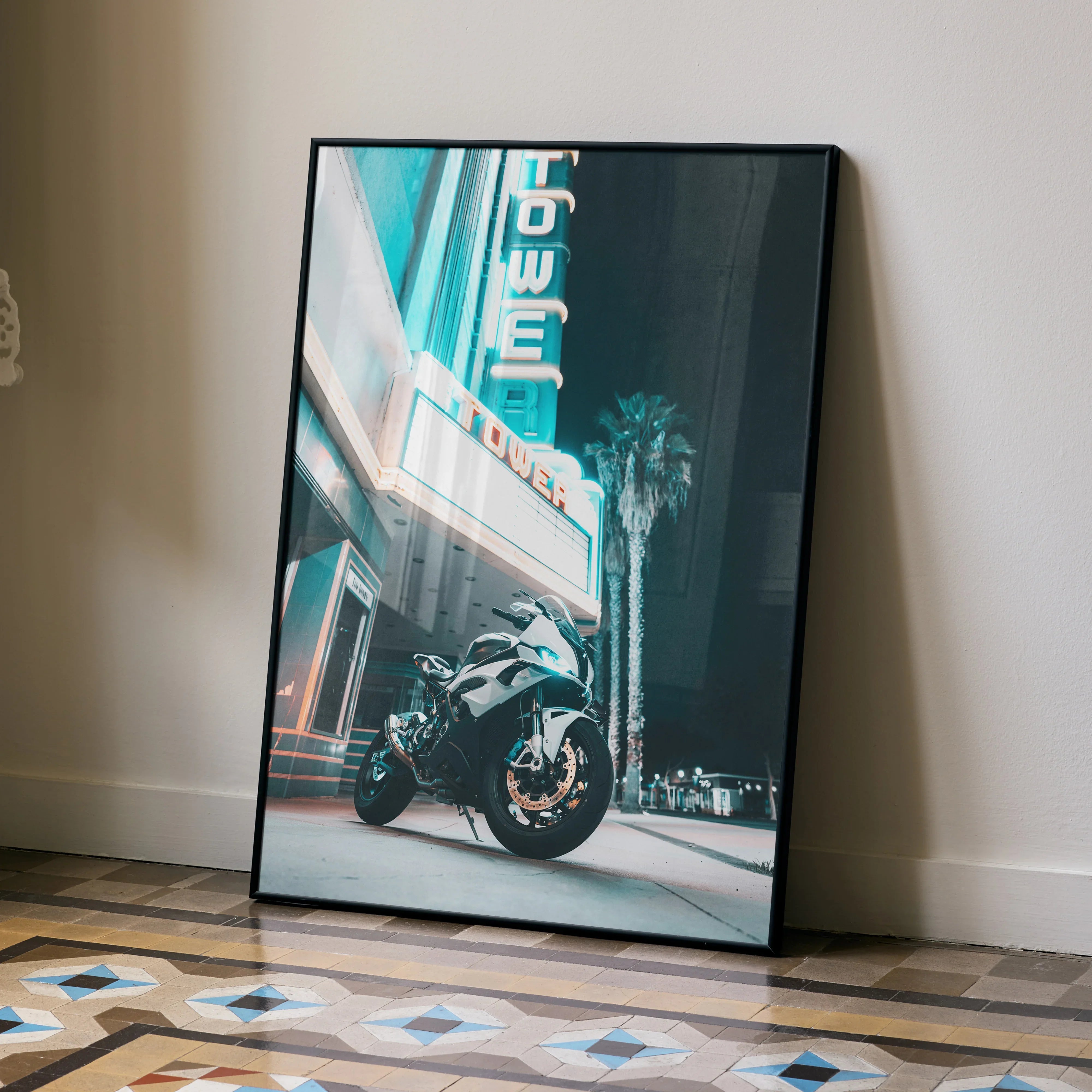 BMW S1000RR motorcycle poster leaning against wall with neon signage, premium wall art in urban night setting.