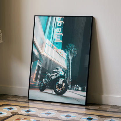 BMW S1000RR motorcycle poster leaning against wall with neon signage, premium wall art in urban night setting.