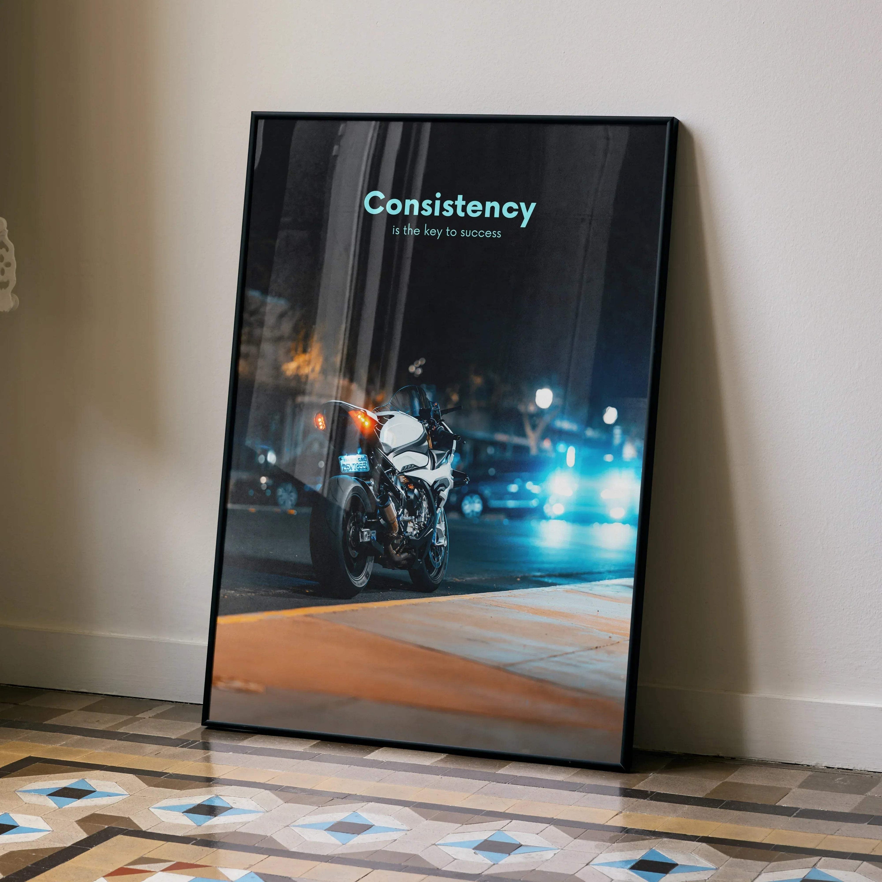 Motivational poster wall art with BMW S1000RR motorcycle and Inspiring Consistency text at night.