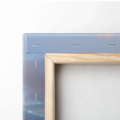 Close-up of wooden frame and stapled edge on vertical canvas wall art with printed blue and gray tones.