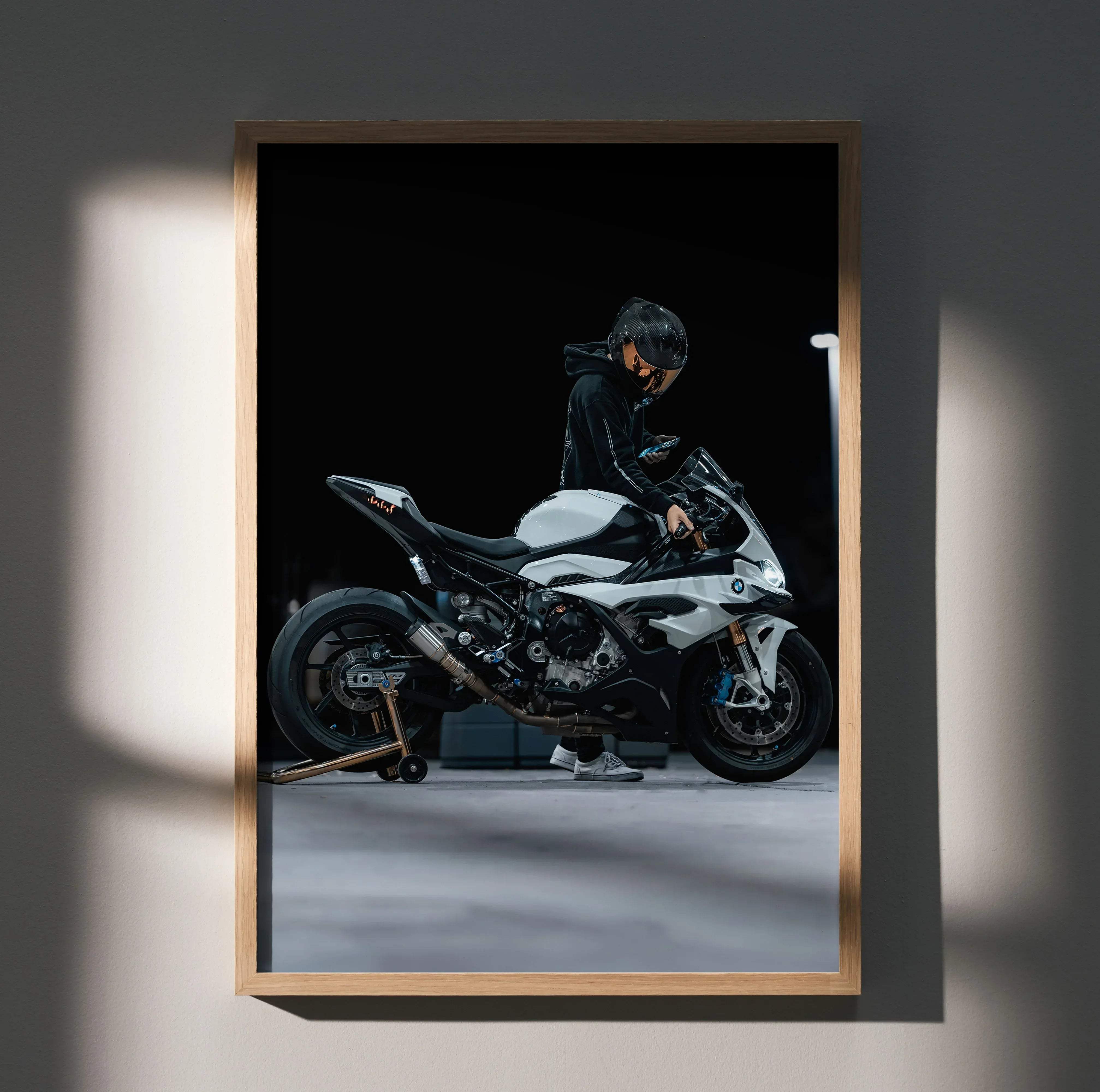 Framed photograph of a white and black bmw s1000rr motorcycle with a rider wearing a scorpion r1 helmet in full gear