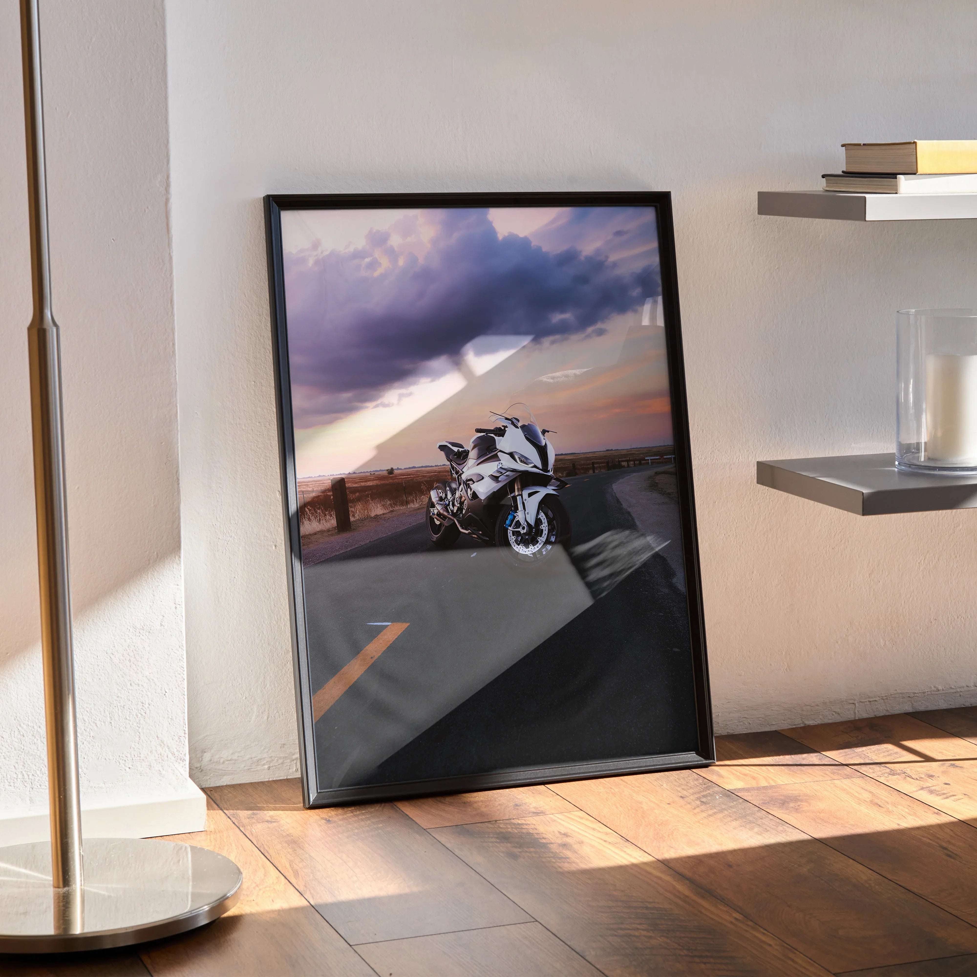 BMW S1000RR motorcycle poster with sunset sky, modern black frame wall art leaning on hardwood floor.