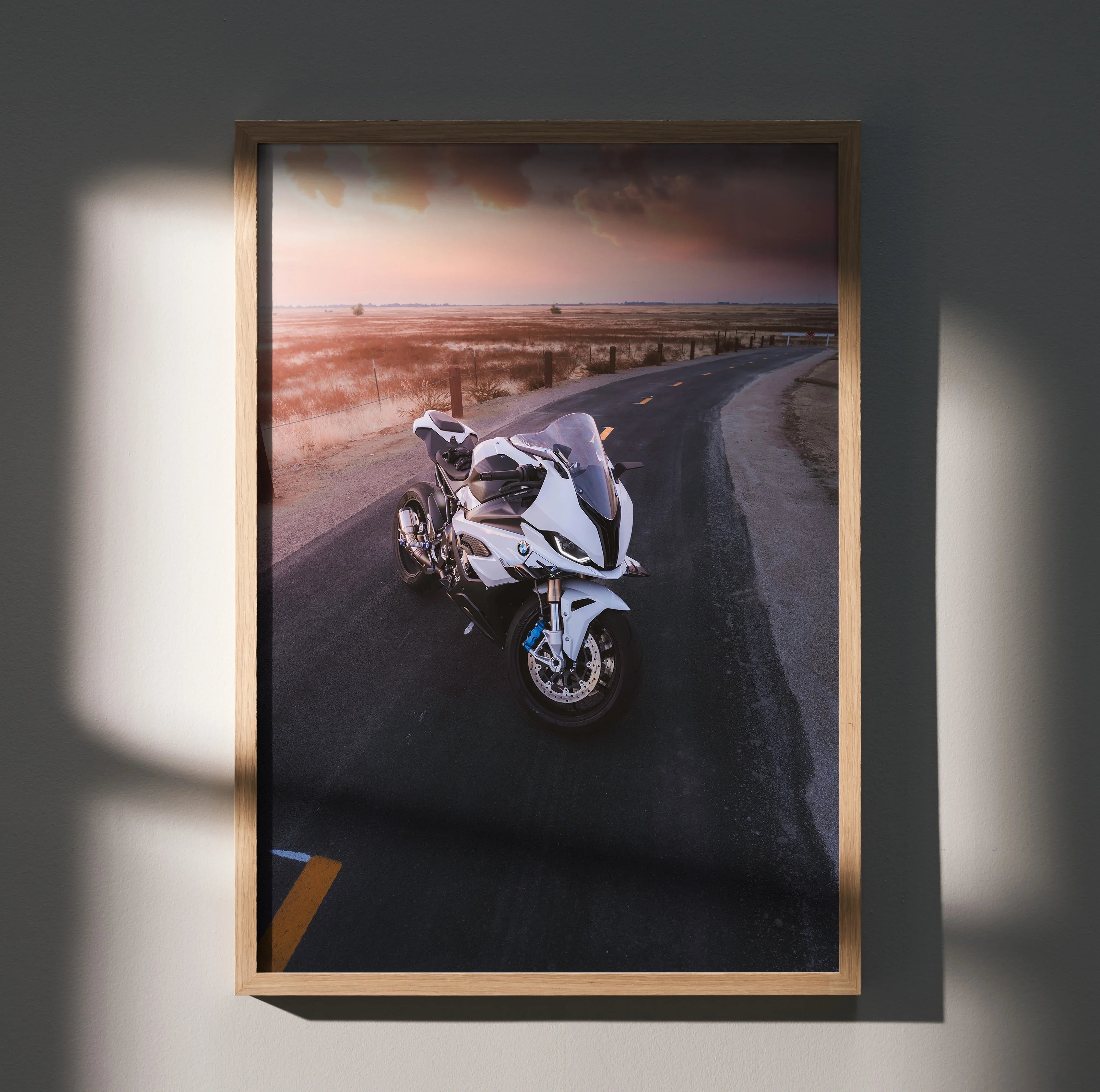 BMW S1000RR motorcycle parked on curved road at sunset poster wall art in wooden frame.