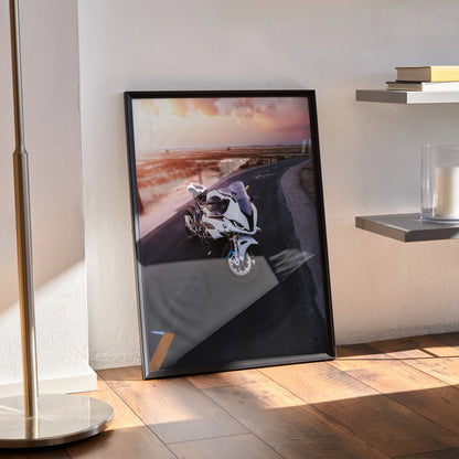BMW S1000RR motorcycle poster wall art with sunset road scene in black frame.