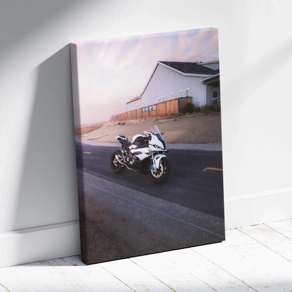 Vertical canvas art featuring a BMW S1000RR motorcycle on a street near a white building at sunset wall art.