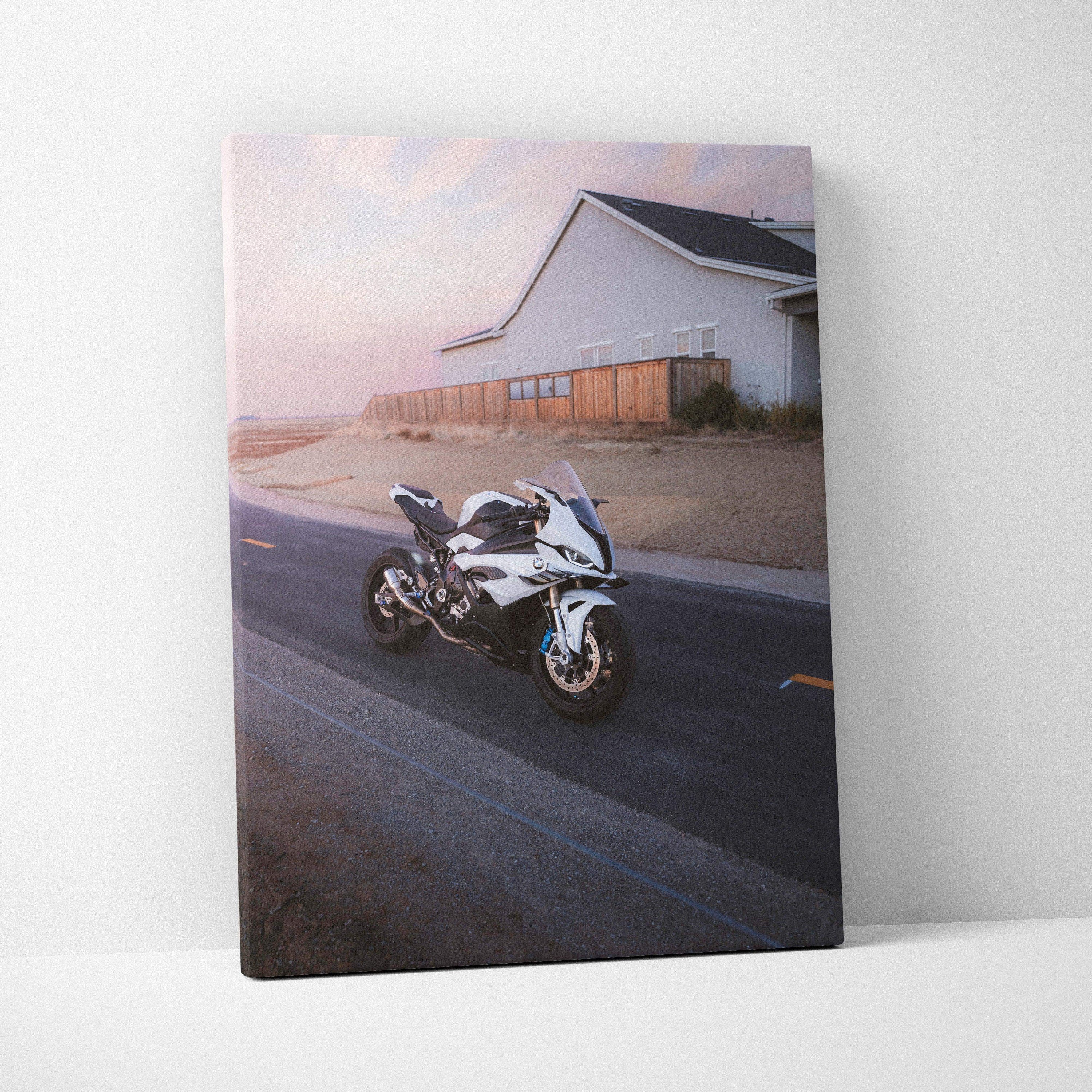 Vertical canvas wall art featuring a BMW S1000RR motorcycle on a desert road at dusk.