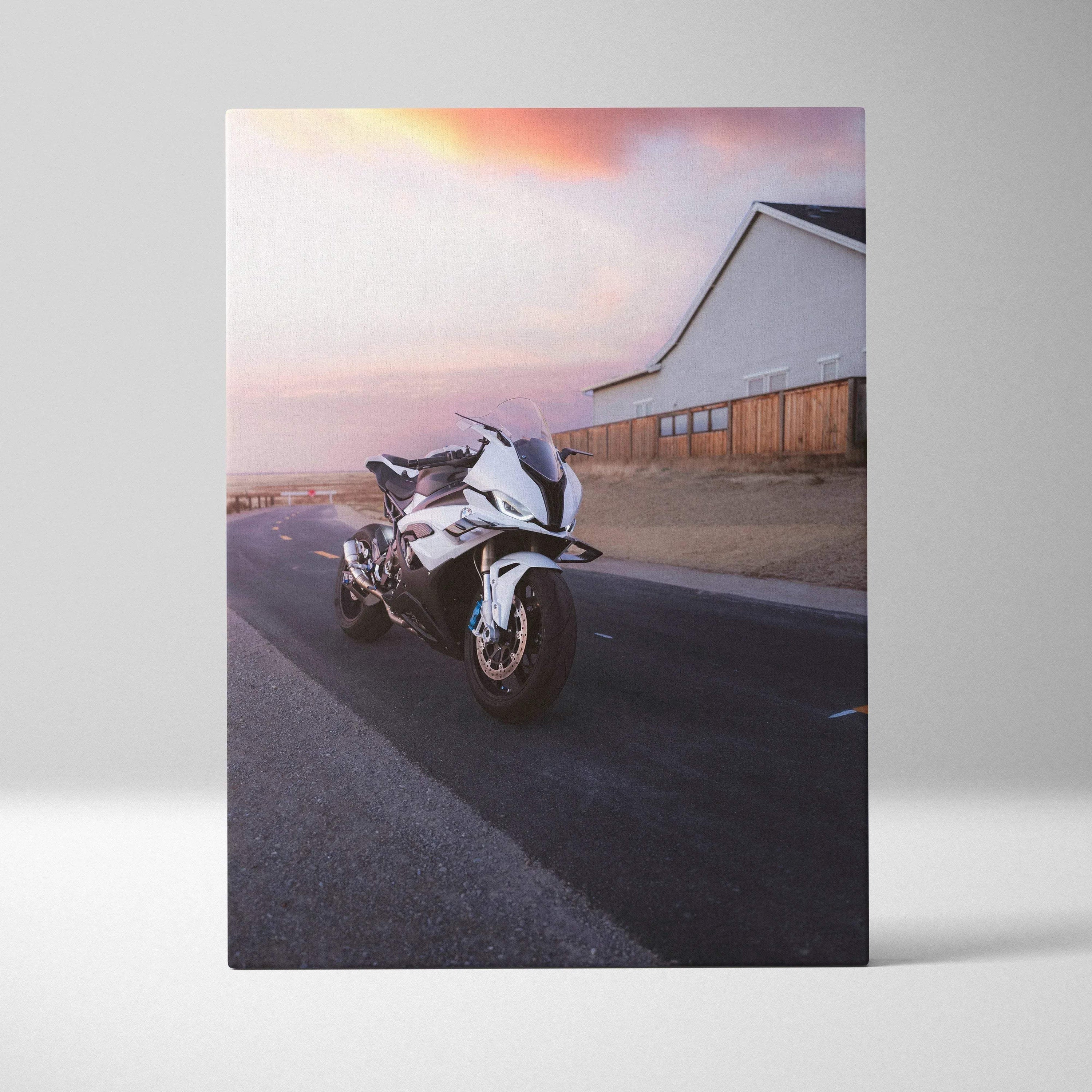 Vertical canvas wall art featuring a BMW S1000RR motorcycle on a road at sunset.