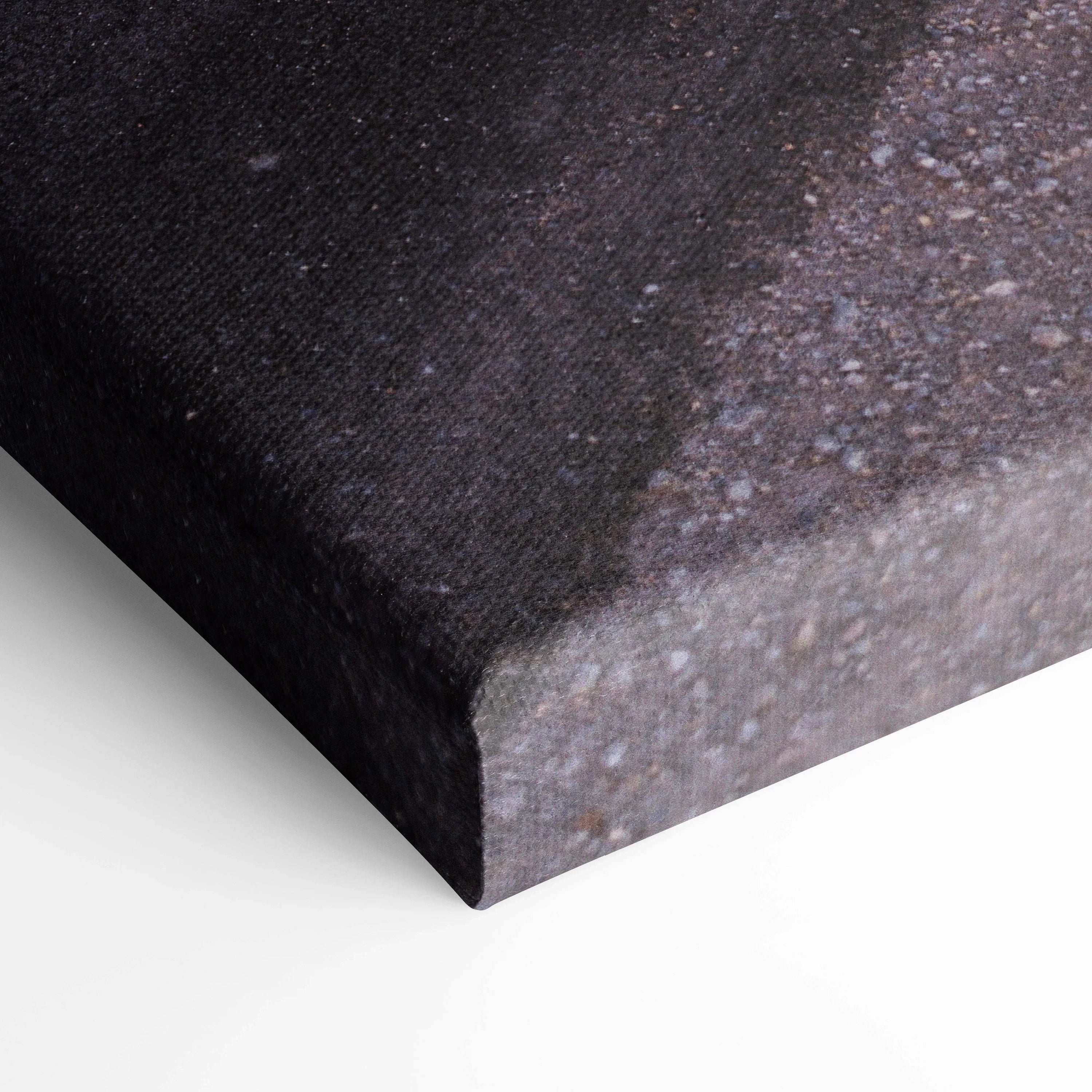 Close-up of textured black and gray canvas art edge with museum-quality finish and stretched wrap for wall art display.