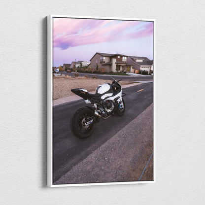 Vertical canvas wall art featuring a BMW S1000RR motorcycle on a suburban street under a pink sky.