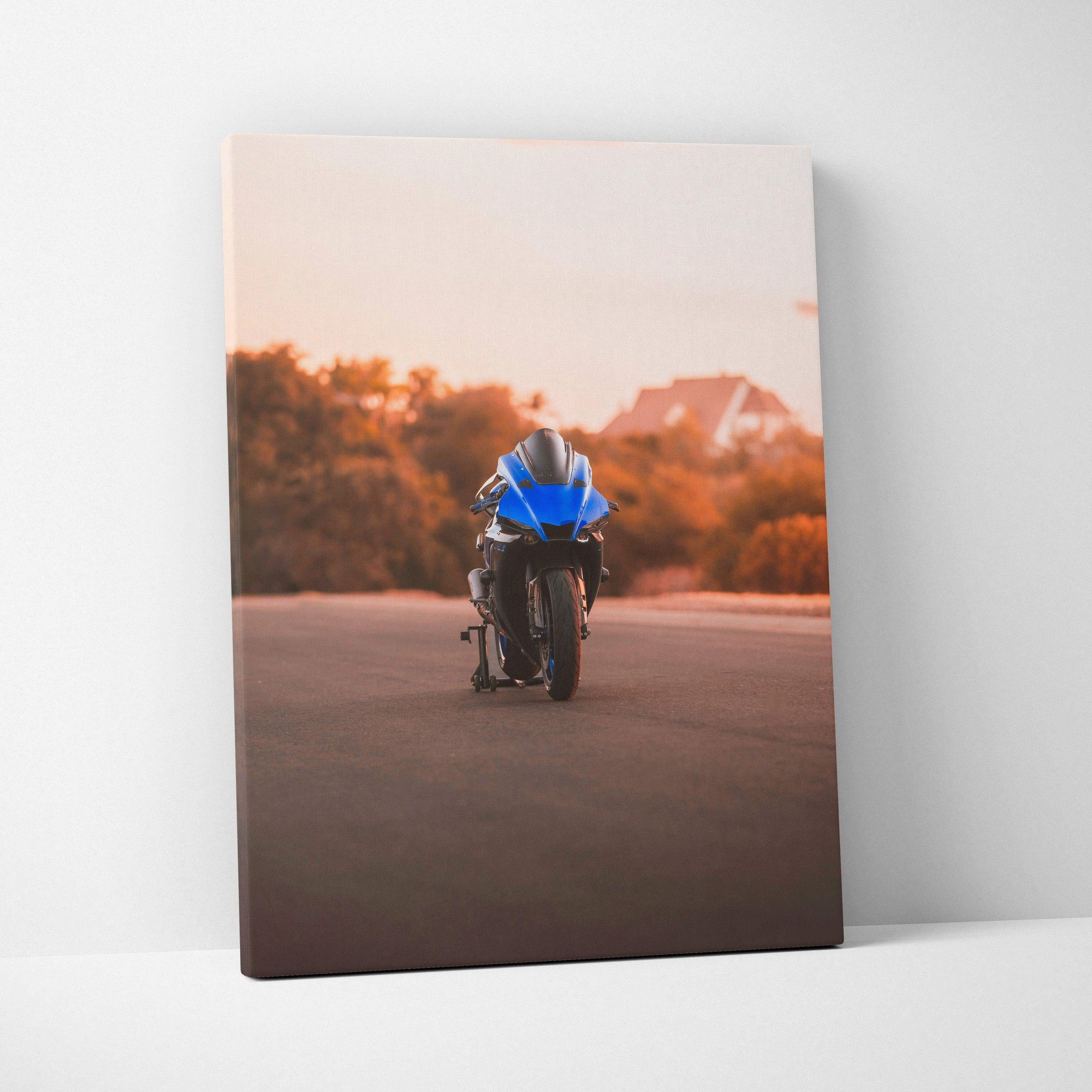 Vertical canvas wall art featuring a blue Yamaha R1 motorcycle on a sunset road with warm orange trees and hills background.